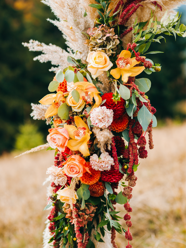 Boho spanish wedding arch flowers. Orange, neutral, nude, and blush pink. Roses, orchids, carnations, amaranthus, and eucalyptus.