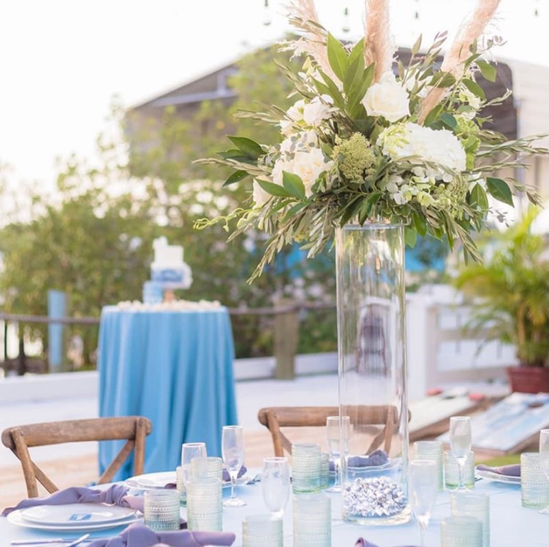 Blue and white boho beach wedding. All white hydrangeas, roses, carnations, and pampas grass.