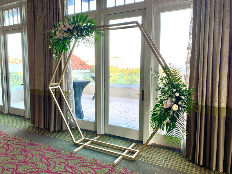 Simple tropical leaf and flower geometric hexagon wedding arch.