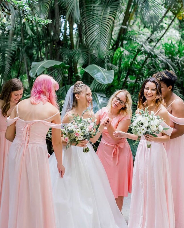 Bride and bridesmaids holding their pink and white garden bouquets. Outdoor wedding at the beautiful Sunken Gardens in St Pete, FL.