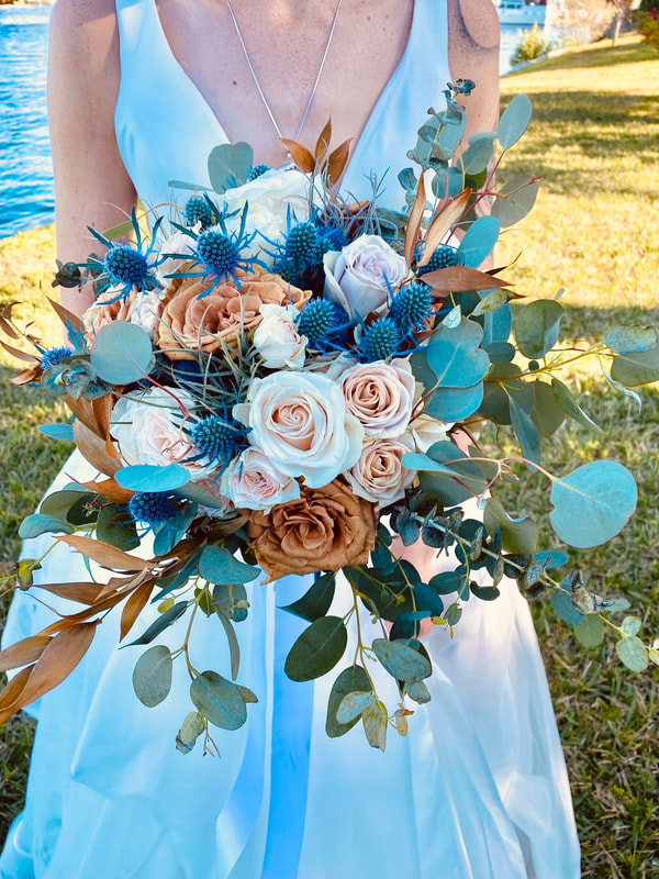 Rustic bridal bouquet in blush, rust, and blue. Roses, thistle, eucalyptus, and dried flower accents.