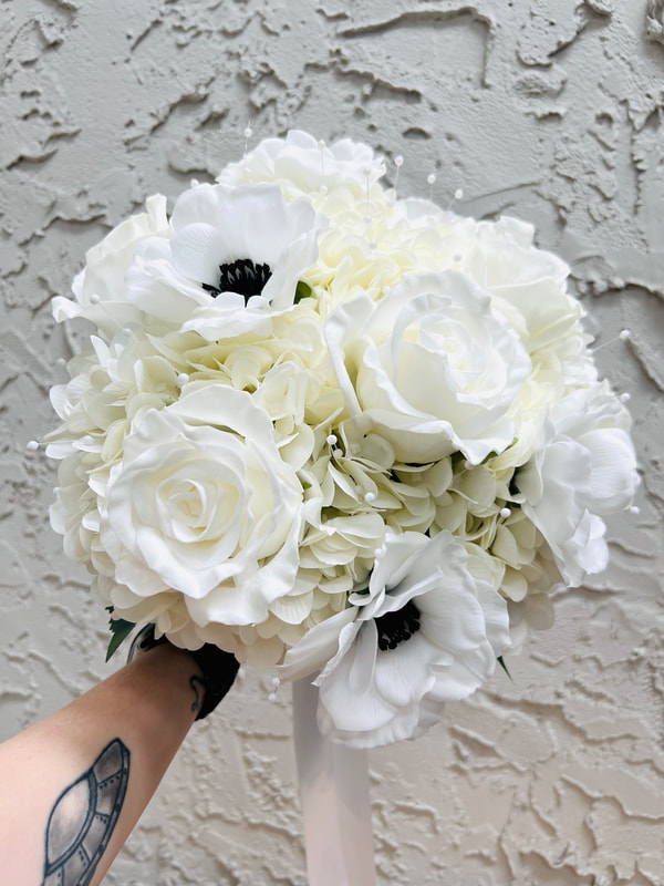 All white classic romantic bridal bouquet for black tie wedding. Hydrangeas, roses, anemones, and pearl accents. No greenery.
