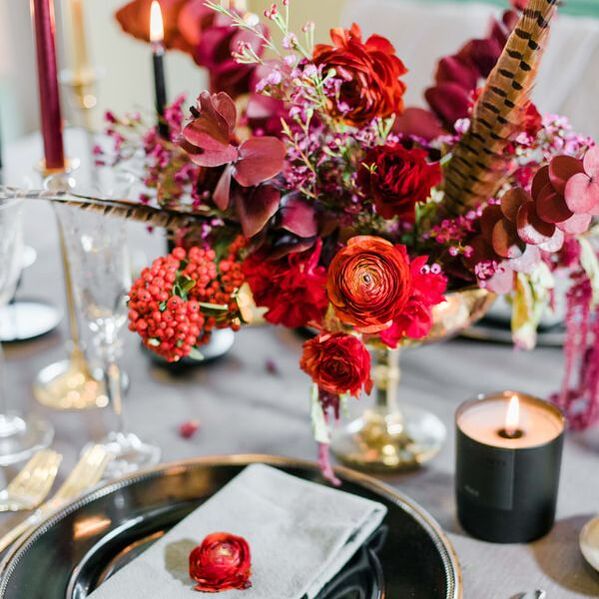 Corporate glam event flower centerpiece in gold, red, and burgundy.