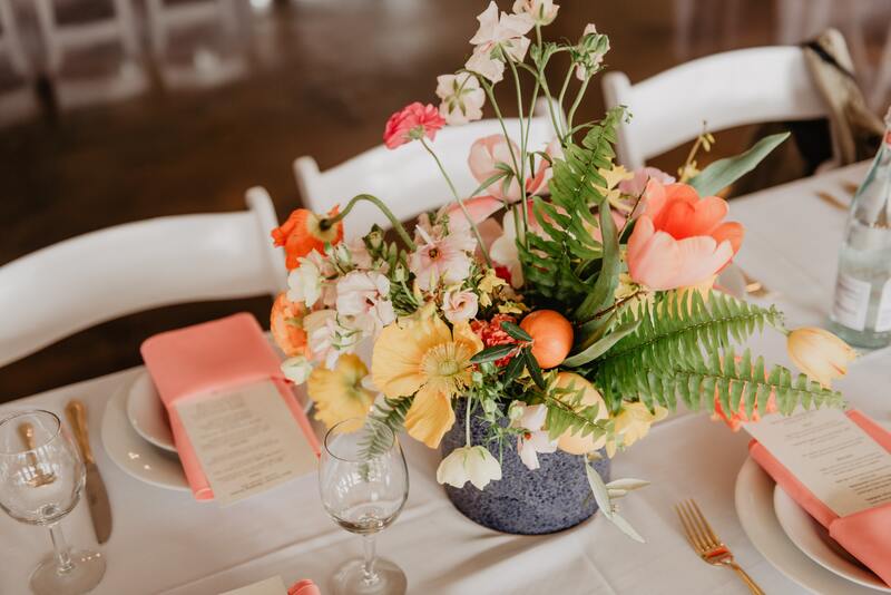 Spring/summer peach, yellow, and blush pink floral centerpieces.